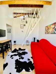 a living room with a red couch and a cow rug at Apartment Direct Views of Eiffel Tower & Sacré-Coeur from Mezzanine - 10 mins to Paris Center in Paris