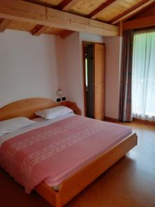 een slaapkamer met een groot bed in een kamer bij Albergo Scoiattolo in Tret