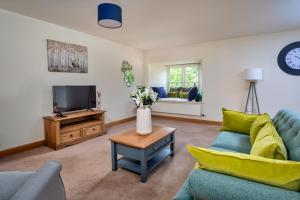 sala de estar con sofá azul y TV en Finest Retreats - Victory Mill - Apartment One, en Pickering