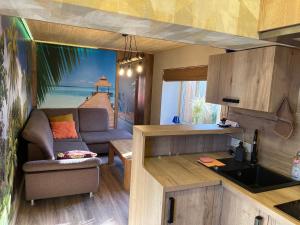a living room with a couch and a kitchen at kotedza Tīkli 2 in Bigauņciems