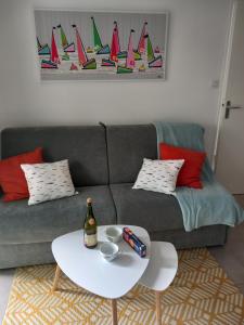 a living room with a gray couch with a white table at le loft de la riviéra in Bénodet
