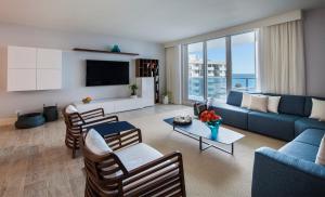 sala de estar con sofá azul y sillas en Incredible Ocean Views! Terrace, 1800 sq.ft., Hotel, en Miami Beach