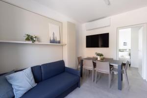 sala de estar con sofá azul y mesa en Bnbook Residenza Locatelli, en Rho