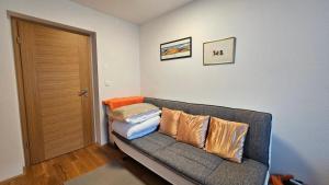 a living room with a couch with pillows on it at Apartma Sava-Stol in Jesenice