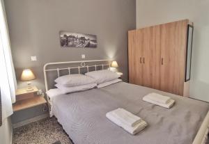 a bedroom with a bed with two towels on it at GARNET 3 in Kalamata