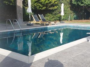 una piscina con due sedie e un tavolo da picnic accanto ad essa di Villa Angela a Droushia