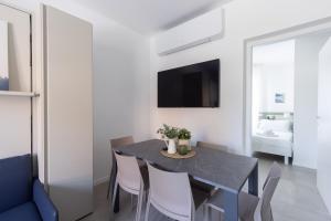 a dining room with a black table and chairs at Bnbook Residenza Locatelli in Rho