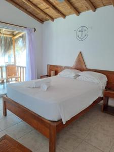 ein Schlafzimmer mit einem großen Bett mit weißer Bettwäsche in der Unterkunft Hotel Casa Mediterranea Mancora in Máncora
