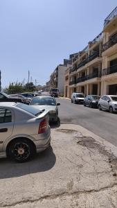 a group of cars parked in a parking lot at Luxury en-suite Double. Beach-house with Sea Views in Mellieħa