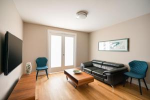 sala de estar con sofá de cuero negro y 2 sillas en Apartment in Columbus Avenue, en Nueva York