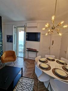 une salle à manger avec une table, des chaises et un lustre dans l'établissement Vista Monaco, 5mn walk to Monaco, Amazing view, à Beausoleil