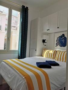 - une chambre avec un lit à rayures jaunes et blanches dans l'établissement Vista Monaco, 5mn walk to Monaco, Amazing view, à Beausoleil