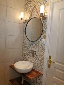 La salle de bains est pourvue d'un lavabo et d'un miroir mural. dans l'établissement Vista Monaco, 5mn walk to Monaco, Amazing view, à Beausoleil