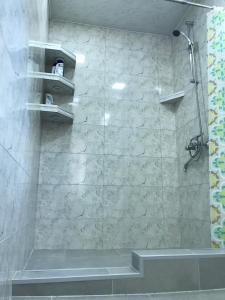 a bathroom with a shower with a stone wall at Гостевой дом Ласточки in Urekhi