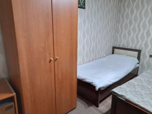 a small bedroom with a small bed and a cabinet at Shahina tur service in Samarkand