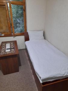 a small room with a bed and a table at Shahina tur service in Samarkand