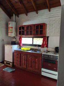 eine Küche mit einem Herd, einer Spüle und einem Kühlschrank in der Unterkunft Molle in Villa Cura Brochero