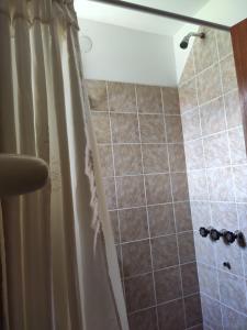 ein Bad mit Dusche und Duschvorhang in der Unterkunft Molle in Villa Cura Brochero