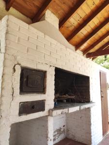 einem Backsteinofen im Freien mit einem Holzdach in der Unterkunft Molle in Villa Cura Brochero