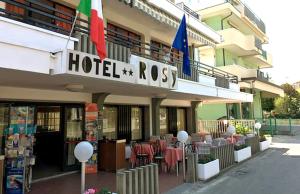 ベッラーリア・イジェア・マリーナにあるHotel Rosyの建物の前にテーブルと椅子があるホテル