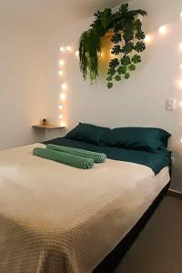 1 dormitorio con 1 cama con una planta colgada en la pared en Nativo House amplio y acogedo, en Medellín