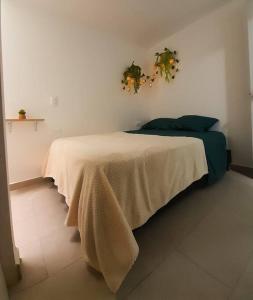 Un dormitorio con una cama con una manta. en Nativo House amplio y acogedo, en Medellín