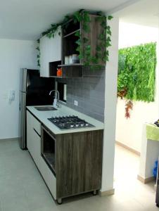 a kitchen with a stove and a sink and a refrigerator at Nativo House amplio y acogedo in Medellín