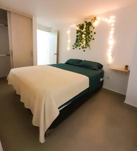 1 dormitorio con 1 cama blanca grande con luces. en Nativo House amplio y acogedo, en Medellín
