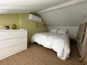 ein Schlafzimmer mit einem weißen Bett und einer weißen Kommode in der Unterkunft villa avec piscine loft cabane in Nîmes