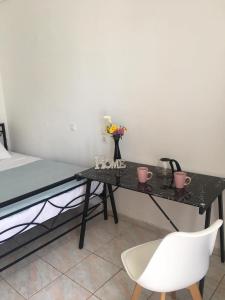 una scrivania nera con un letto e una sedia bianca di Layla' s Petite Home a Città di Kos