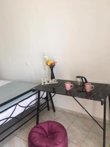 un tavolo nero con un vaso di fiori sopra di Layla' s Petite Home a Città di Kos