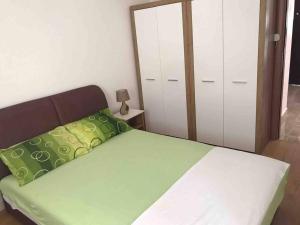 1 dormitorio con 1 cama con sábanas verdes y espejo en New Comfortable Apartment in Bijela - Appart numéro 2, en Bijela