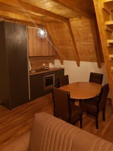 uma sala de jantar com mesa e cadeiras e uma cozinha em Dawn Villas em Ferizaj