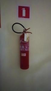 a red fire extinguisher hanging on a wall at Pousada Terra do Sol in Fortaleza