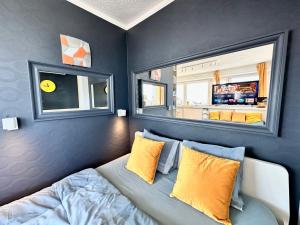 Un dormitorio con una cama con almohadas amarillas y una ventana en SUN clima/AC metro x2 Fast WiFi 500 Mbs 70’TV Netflix AppleTV HBO en Varsovia