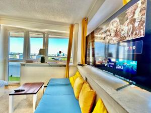 sala de estar con sofá y TV grande en SUN clima/AC metro x2 Fast WiFi 500 Mbs 70’TV Netflix AppleTV HBO en Varsovia