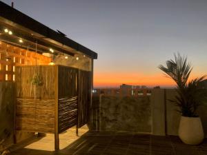 a rooftop deck with a sunset in the background at Hellen House Bello Horizonte in Santa Marta
