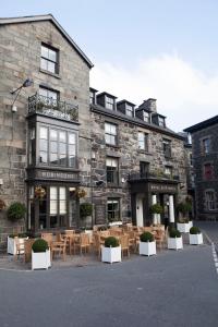 a building with tables and chairs in front of it at Royal Ship in Dolgellau