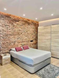 Un dormitorio con una pared de ladrillo y una cama en Cómodo y Moderno piso en el centro de Santander, en Santander