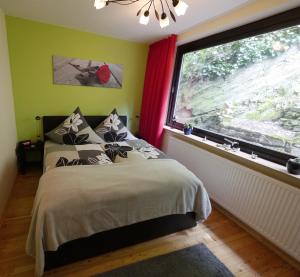 a bedroom with a bed and a large window at Alkener Elfenhaus mit kostenlosen Gäste Ticket in Alken