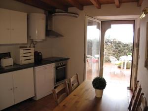 a kitchen with a table and chairs and a door to a patio at Casa do Castelo - Muralha in Castelo de Vide