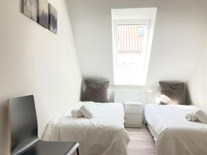two beds in a small room with a window at Three-Bedroom Apartment In Fredericia in Fredericia