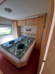 een kleine slaapkamer met een bed in een kleine kamer bij Holiday in Holland - no workmen only holiday makers in Vierhouten