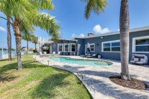 a house with a swimming pool and palm trees at Luxury St Petersburg Home with Pool and Bay Access! in St Pete Beach