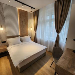 a bedroom with a white bed and a chair at City Nest Modern & Cozy Suites in Belgrade