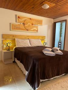 a bedroom with a large bed with a clock on the wall at Recanto das Cerejeiras in Campos do Jordão