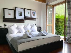 Un dormitorio con una cama blanca con toallas. en Regina di Laglio - Free Parking, Garden, Lake View, en Laglio