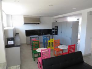 a kitchen with colorful chairs and a table at ALOJAMIENTOS AVICHE 6 in Santander