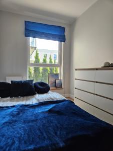 Un dormitorio con una cama azul y una ventana en Nadmorski apartament premium, en Gdynia