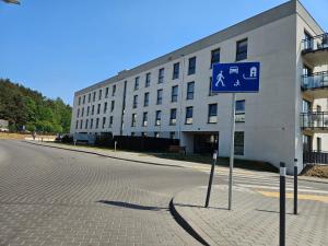 um sinal de rua azul em frente a um edifício em Nadmorski apartament premium em Gdynia